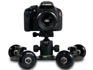 A black Revolve table-top skate camera dolly with adjustable rotating axles and smooth wheels, designed for capturing tracking video shots on flat surfaces.